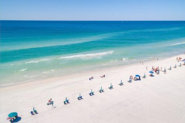 Aerial view of the white sand beach and emerald coast Gulf waters at Silver Shells in Destin, Florida.