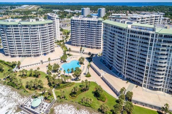 Aerial view of Silver Shells Beach Resort and Spa towers, lagoon pool, and landscaped grounds in Destin, Florida.